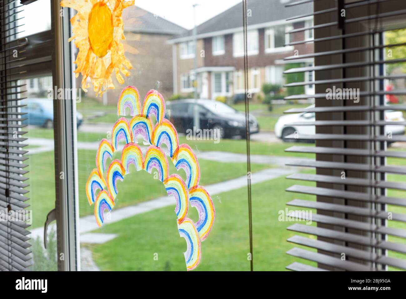 Kinder Zeichnungen von Regenbögen in einem Fenster während des Covid-19-Lockdown in großbritannien Stockfoto