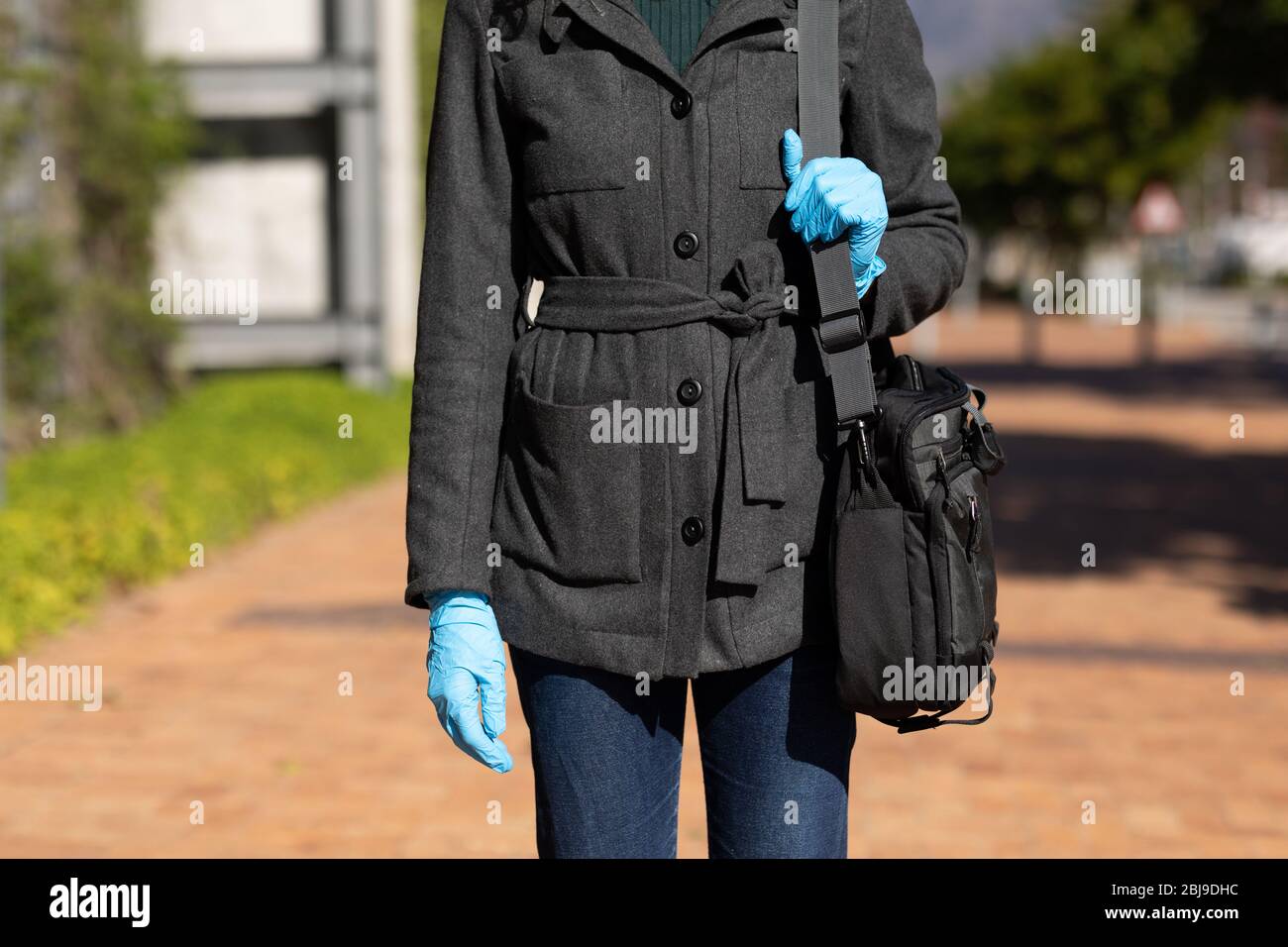 Kaukasische Frau mit Schutzhandschuhen gegen Coronavirus Stockfoto