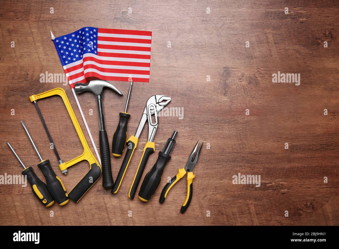 Werkzeuge auf einem hölzernen Hintergrund. Konzept des Arbeitstages Stockfoto