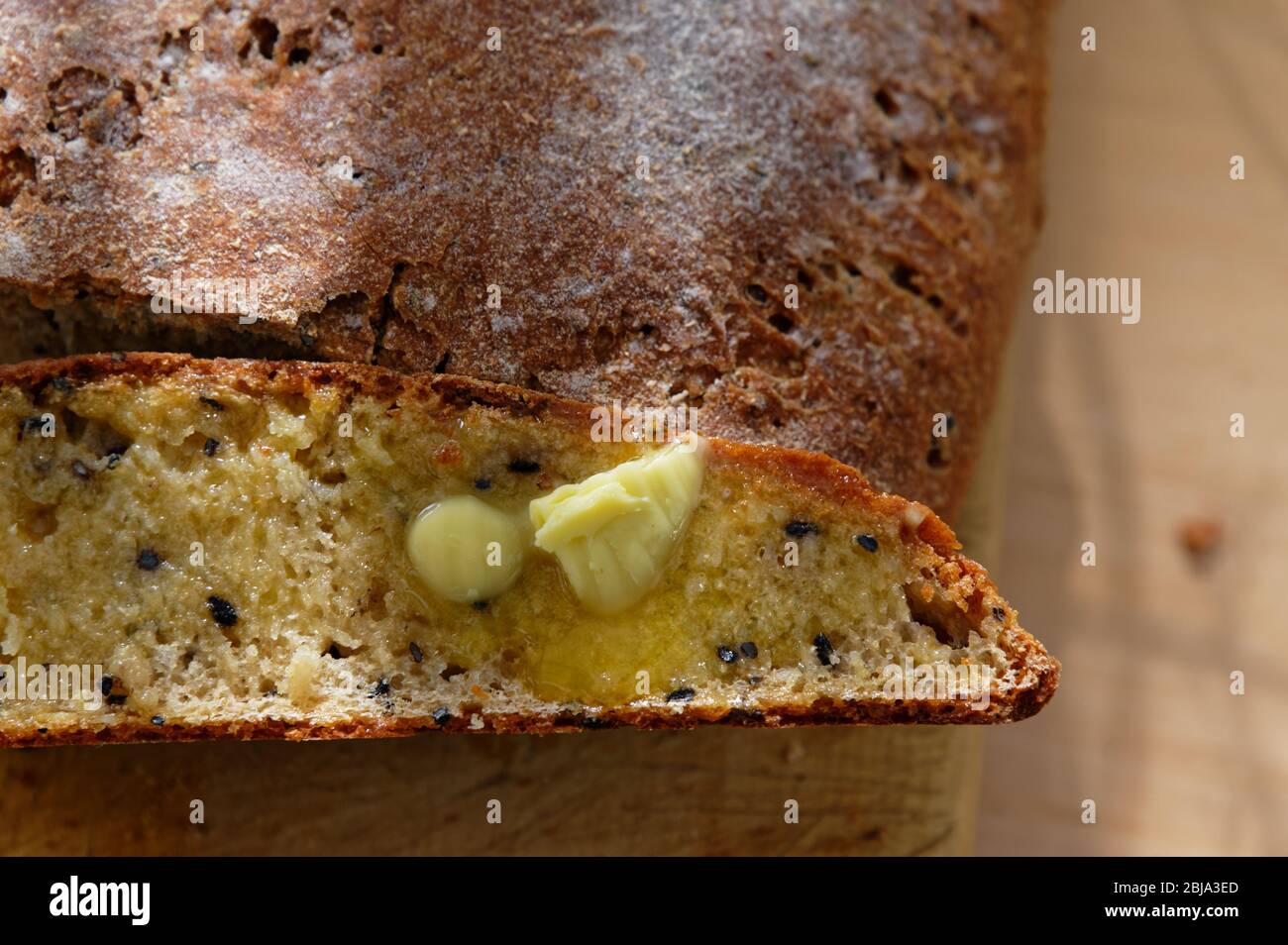 Butter schmilzt auf einer Scheibe frischem, vollkornem, hausgemachtem Brot Stockfoto