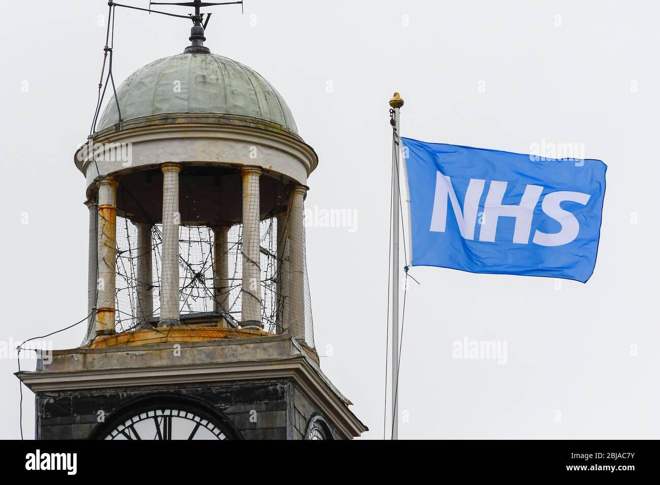 Bridport, Dorset, Großbritannien. April 2020. Wetter in Großbritannien. Eine NHS-Flagge, die an einem nassen bewölkten Morgen auf der Rathauspfahne in Bridport in Dorset fliegt. Bild: Graham Hunt/Alamy Live News Stockfoto