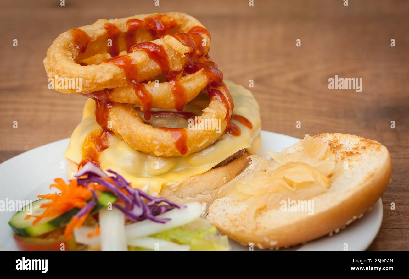 Cheeseburger mit zerschlagene Zwiebelringe gestapelt. Stockfoto