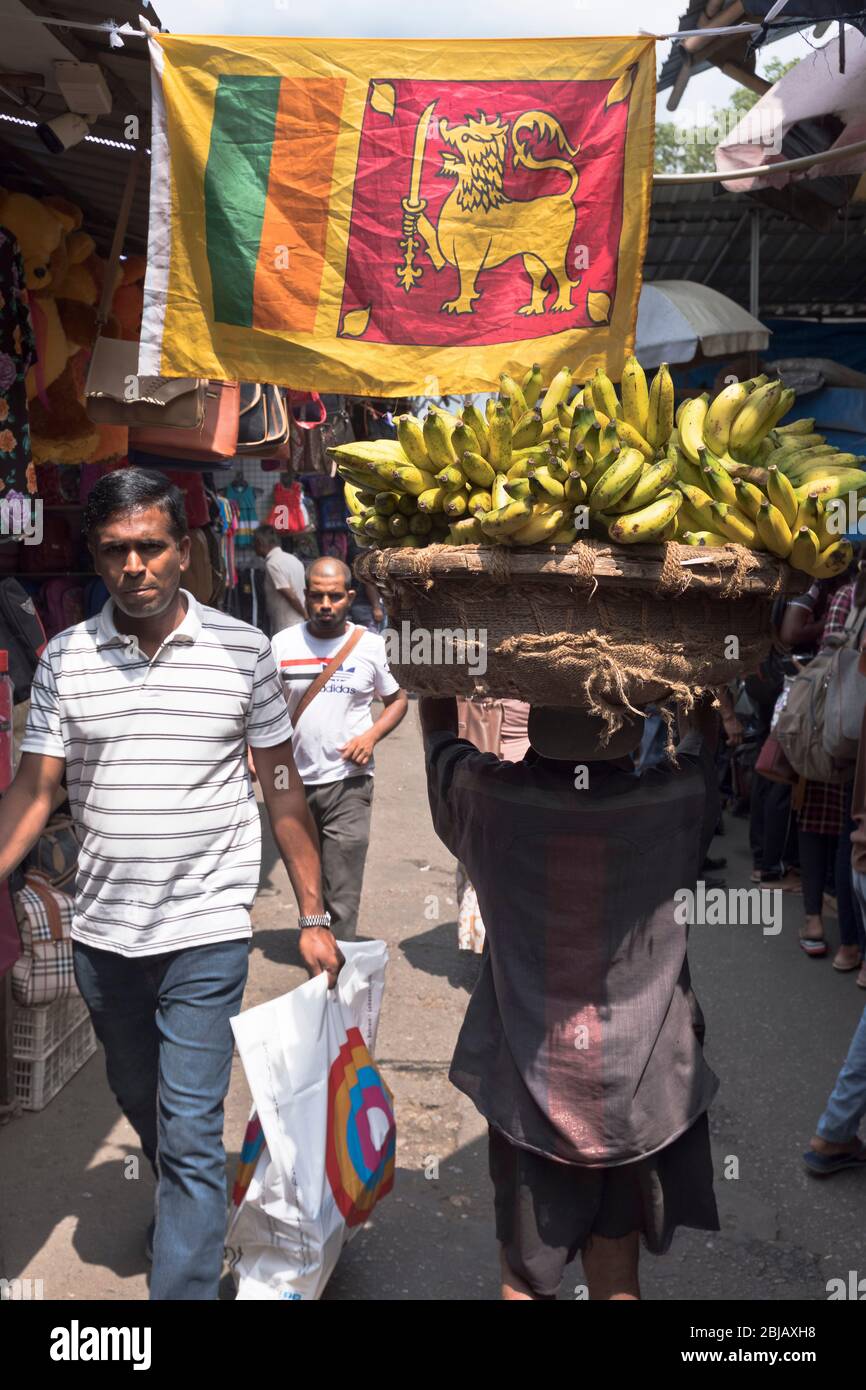 dh COLOMBO SRI LANKA Einheimische Menschen werden in Market Woman angezeigt Mit Bananen Löwenflagge von sri lanka Stockfoto