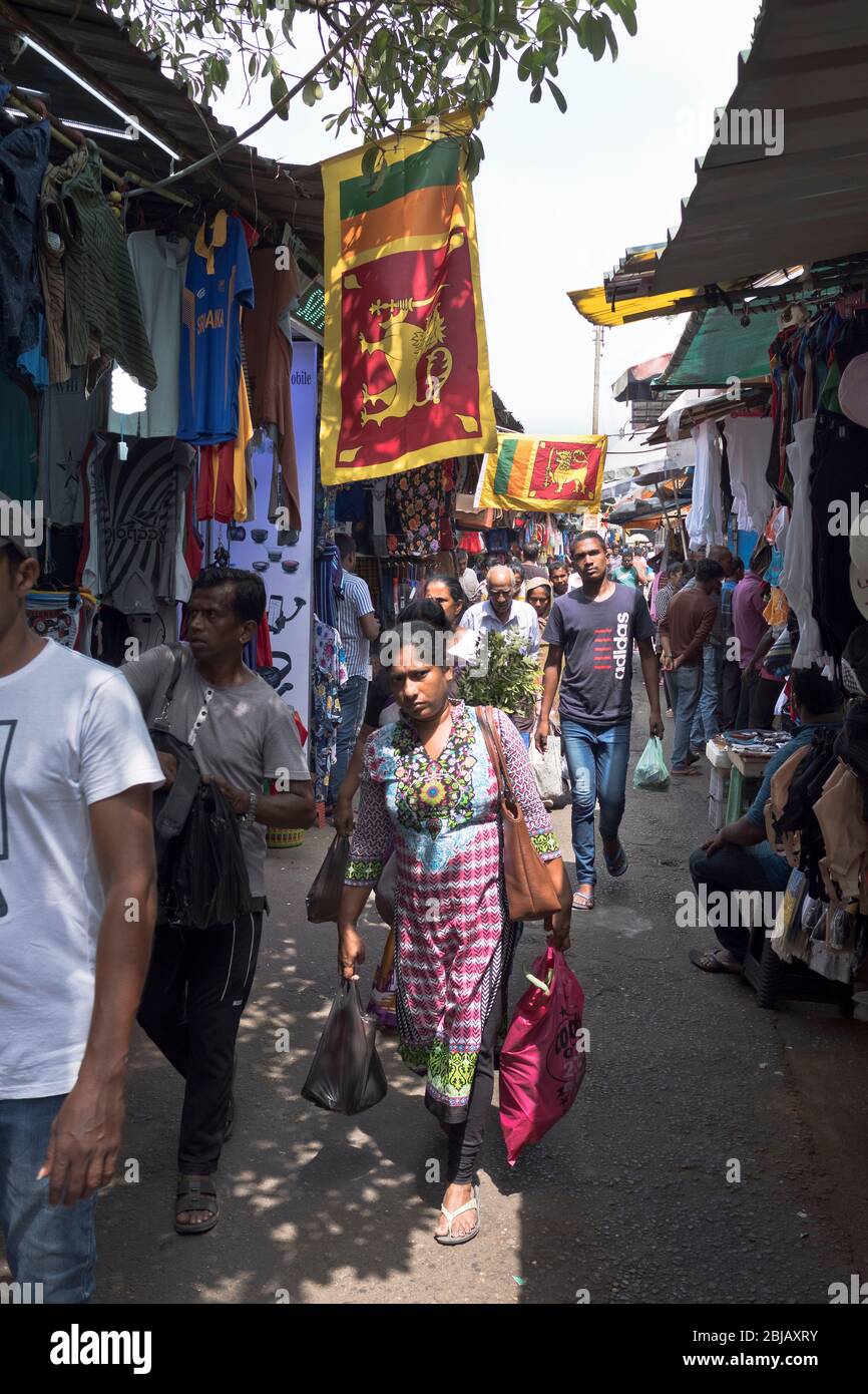 dh Sri lanka Flagge COLOMBO MARKT SRI LANKA ASIEN Lokal asiatische Straße Menschen Fahnen angezeigt Frau tragen von Einkaufen Stockfoto