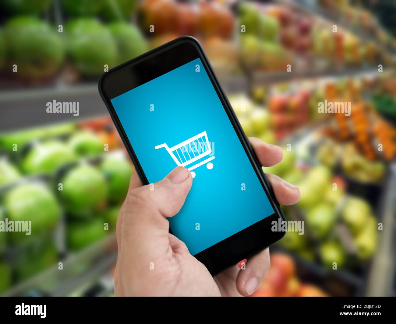 Hand halten Handy mit Lebensmittelgeschäft online auf dem Bildschirm mit Unschärfe Supermarkt Hintergrund Stockfoto