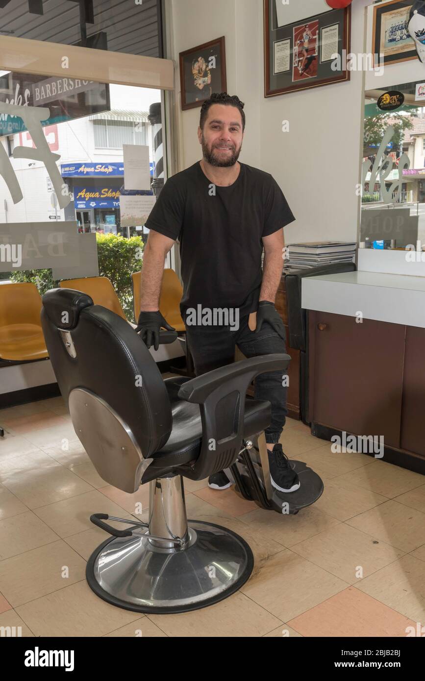 Anthony Vittorino, Besitzer Barber im Frank's Barber Shop im Vorort Gordon in Sydney, trägt Handschuhe und reinigt seine Stühle während der Pandemie regelmäßig Stockfoto