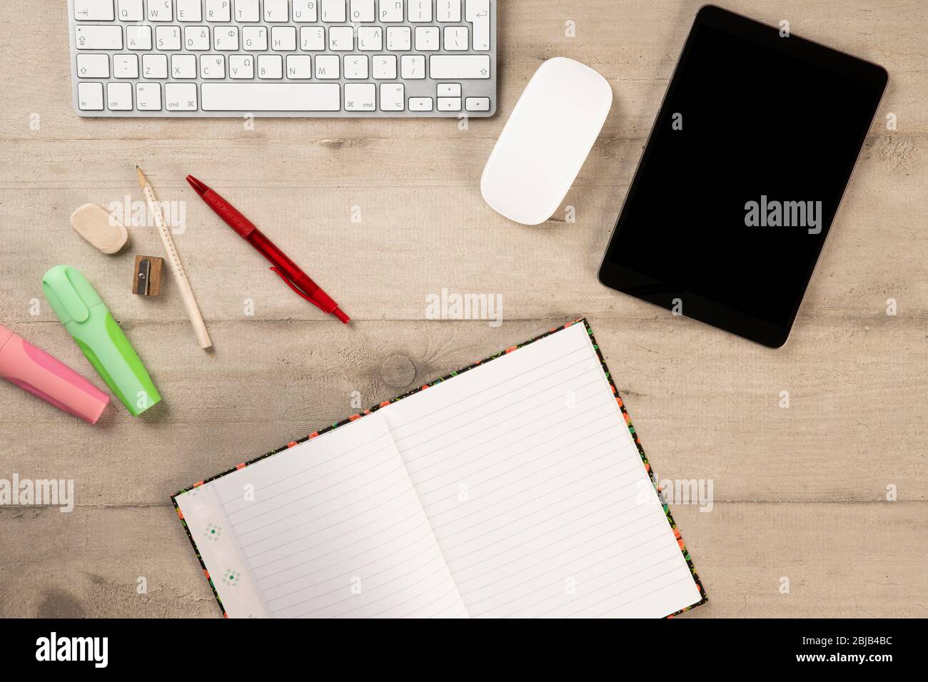 Bürobedarf und Schreibwaren auf einem hölzernen Hintergrund. Tablet, Tastatur und Notebook für die Arbeit von oben Stockfoto