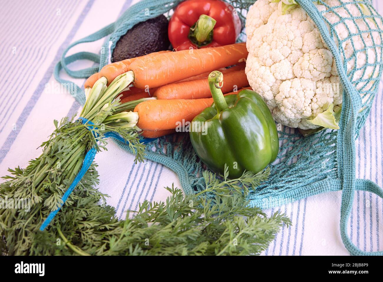 Nahaufnahme von frischen Produkten in Öko-Tasche auf Küchentisch, wiederverwendbar, nachhaltig, umweltfreundlich, kein Kunststoff-Konzept. Verschiedene Gemüse: Paprika, Karotte, ca. Stockfoto