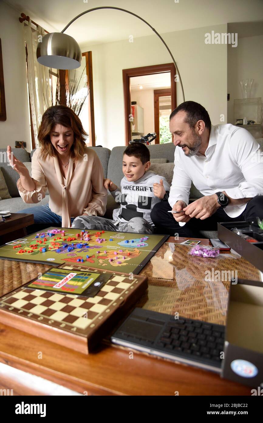 Mailand, Italien. April 2020. Binasco (Mailand), Lupo Daturi 9 Jahre alt, Schöpfer des Videospiels 'Cerba-20 Covid-19', um das Coronavirus zu zerstören- auf dem Foto: Lupo Daturi Mein Vater Marco und Mutter Francesca spielen Risiko Quelle: Unabhängige Fotoagentur/Alamy Live News Stockfoto