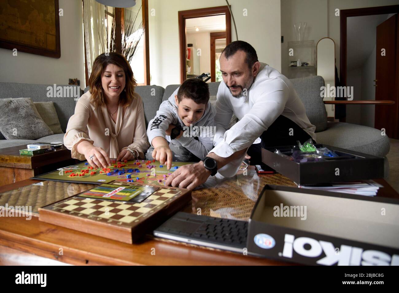 Mailand, Italien. April 2020. Binasco (Mailand), Lupo Daturi 9 Jahre alt, Schöpfer des Videospiels 'Cerba-20 Covid-19', um das Coronavirus zu zerstören- auf dem Foto: Lupo Daturi Mein Vater Marco und Mutter Francesca spielen Risiko Quelle: Unabhängige Fotoagentur/Alamy Live News Stockfoto