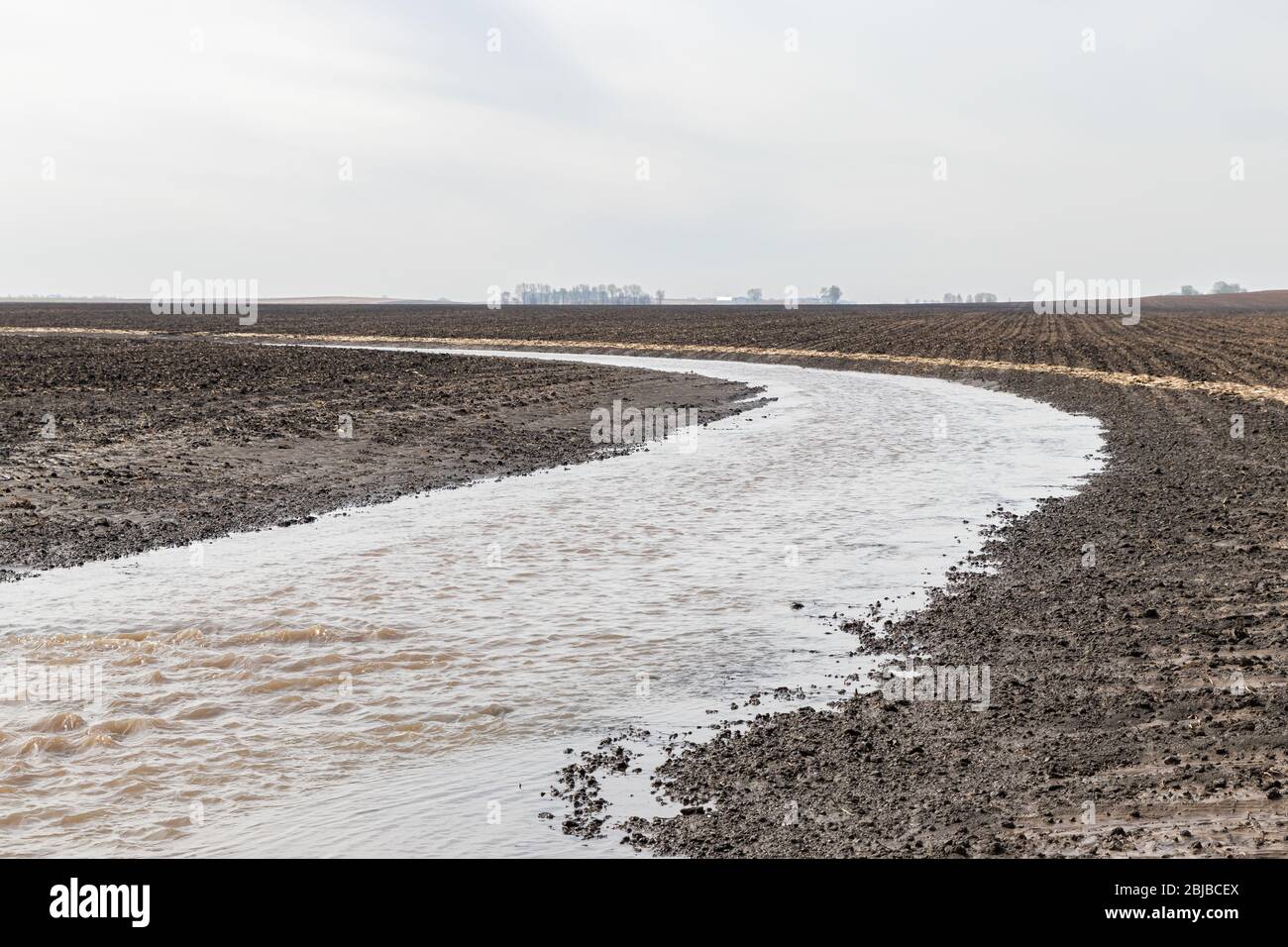 Wasser, das nach heftigen Frühlingsregen und Stürmen in den landwirtschaftlichen Feldern fließt, brachte Überschwemmungen und verzögerte die Pflanzzeit im Mittleren Westen Stockfoto