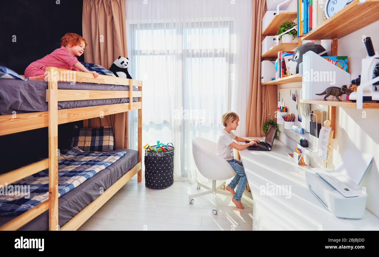 Zwei Jungen, Brüder im Kinderzimmer mit Etagenbett und Wandregalen Stockfoto