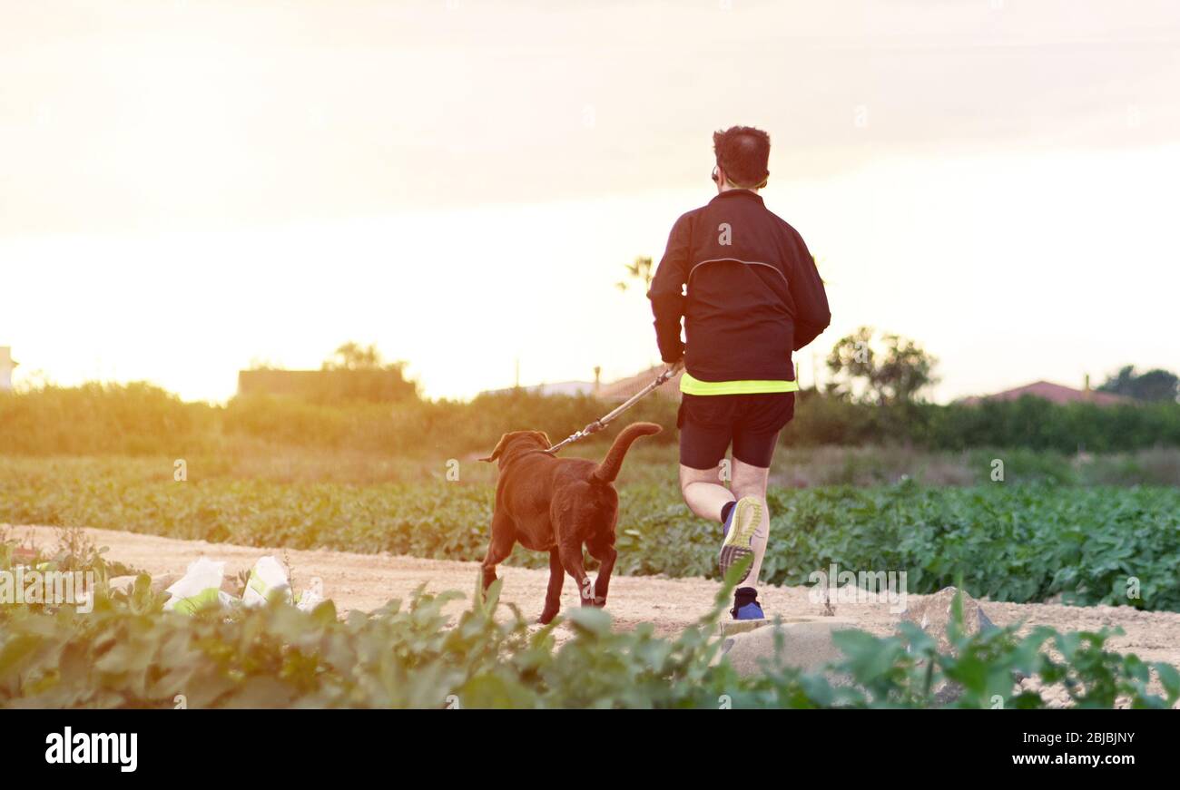 Sportler, die mit seinem Hund während der Phase 1 Deeskalation von Coronavirus oder Covid-19 in Spanien laufen. Es ist erlaubt, einmal pro Woche zu laufen Stockfoto