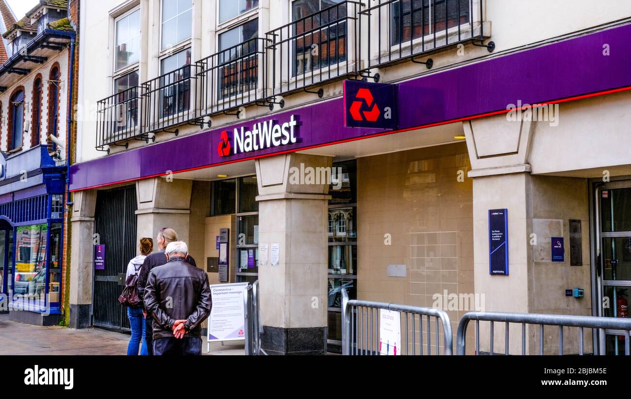 Kunden, die außerhalb EINER Zweigstelle der NatWest Bank in South London Schlange stehen und die Richtlinien zur Sperrung der Regierung über soziale Distanzierung einhalten Stockfoto