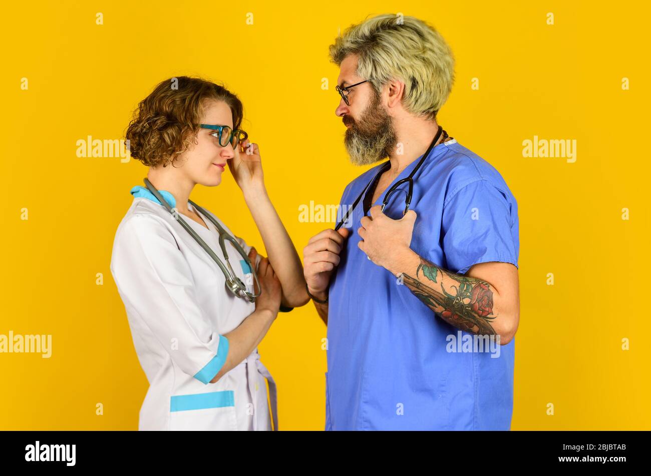 Menschen in Uniformen gelben Hintergrund. Medizinisches Personal. Vertrauen Sie unseren Fachleuten. Healthcare Business. Teamwork und Menschen Konzept. Arzt und Krankenschwester. Erfolgreiches Team von Ärzten. Seien Sie Sicher. Stockfoto