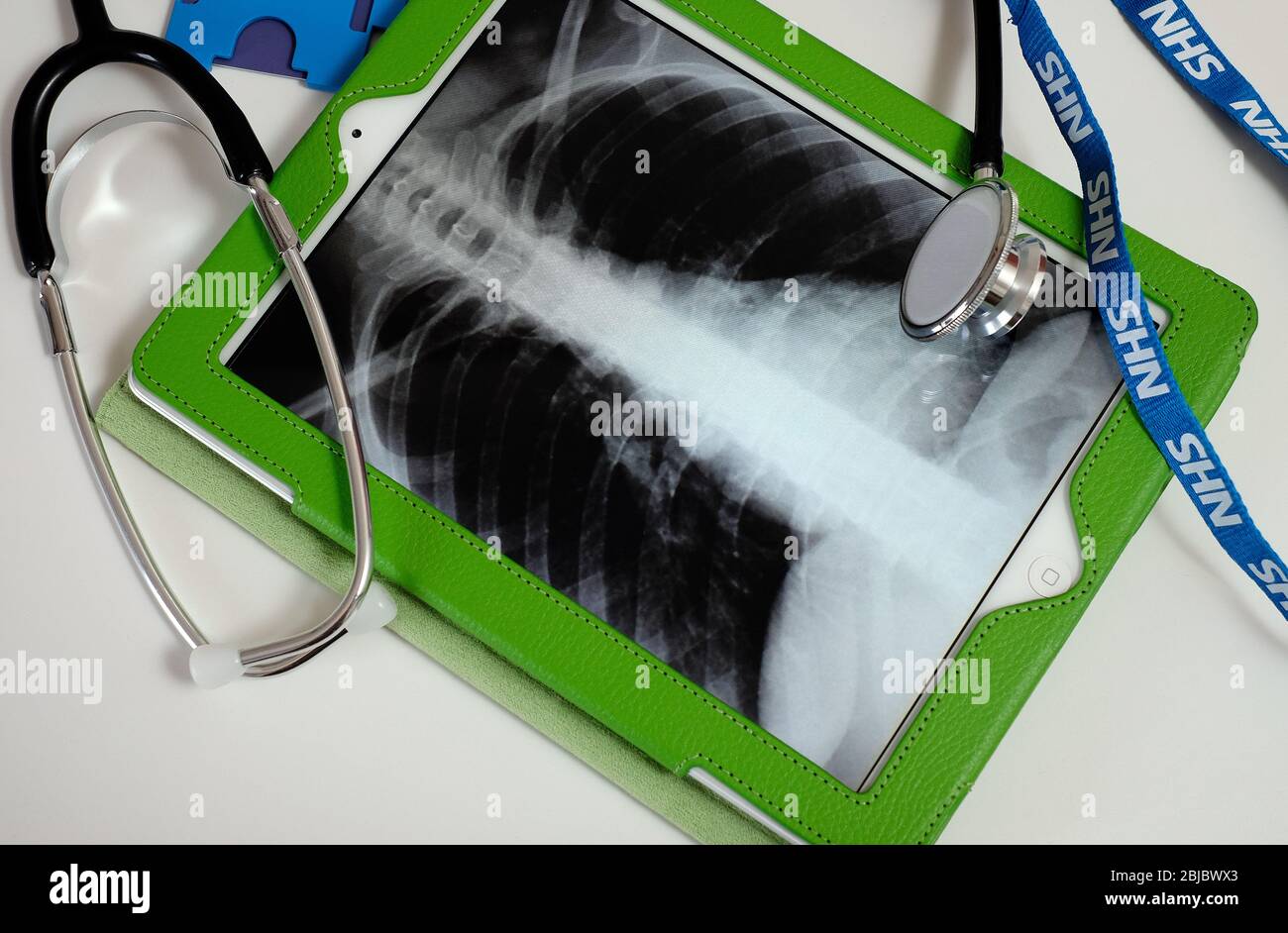 Doktor Stethoskop und nhs Lanyard auf Computer-Tablet zurück Röntgenbild Stockfoto