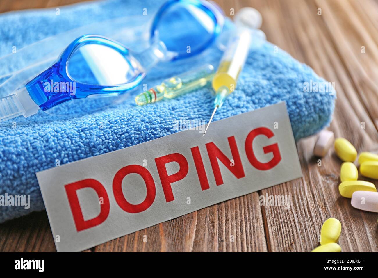 Sportausrüstung, Wort Doping und Spritze auf Holzhintergrund Stockfoto