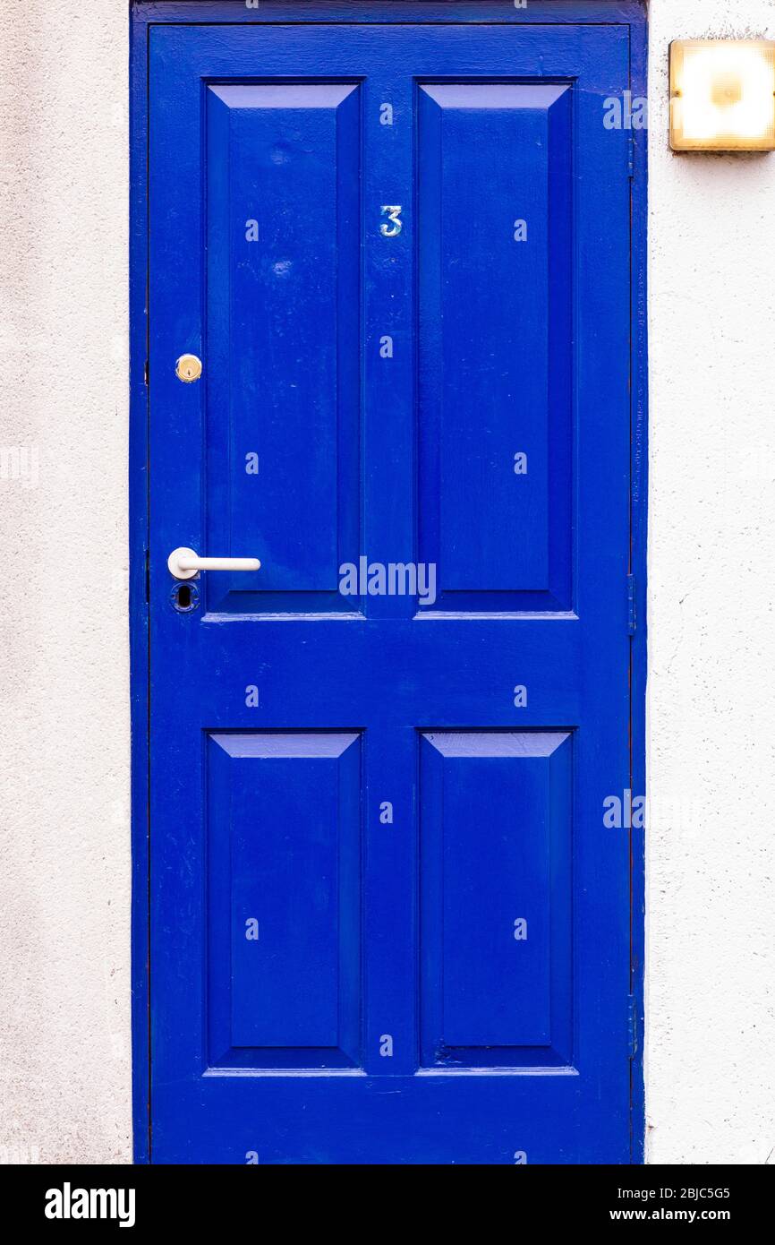 Blaue Holztür mit der Nummer 3 in ihrer Gesamtheit mit weißem Rahmen gesehen Stockfoto