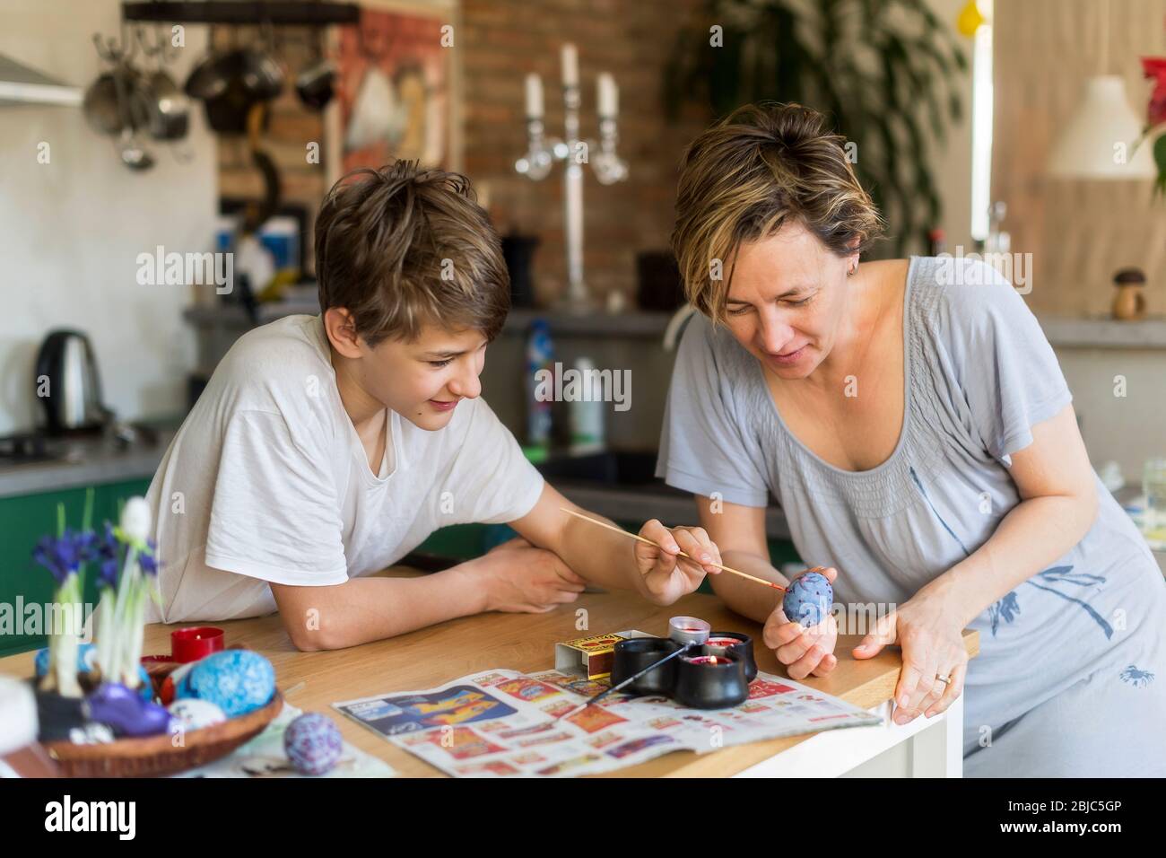 Mutter und Sohn Färbung Osterei zu Hause in der Küche Stockfoto