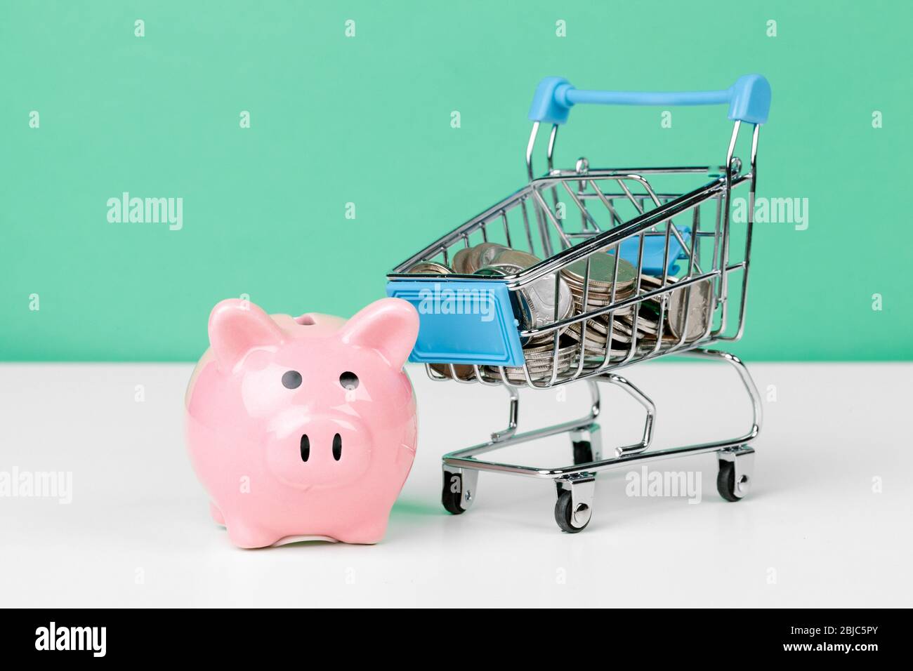 Rosa Sparschwein mit Warenkorb. Nahaufnahme. Stockfoto