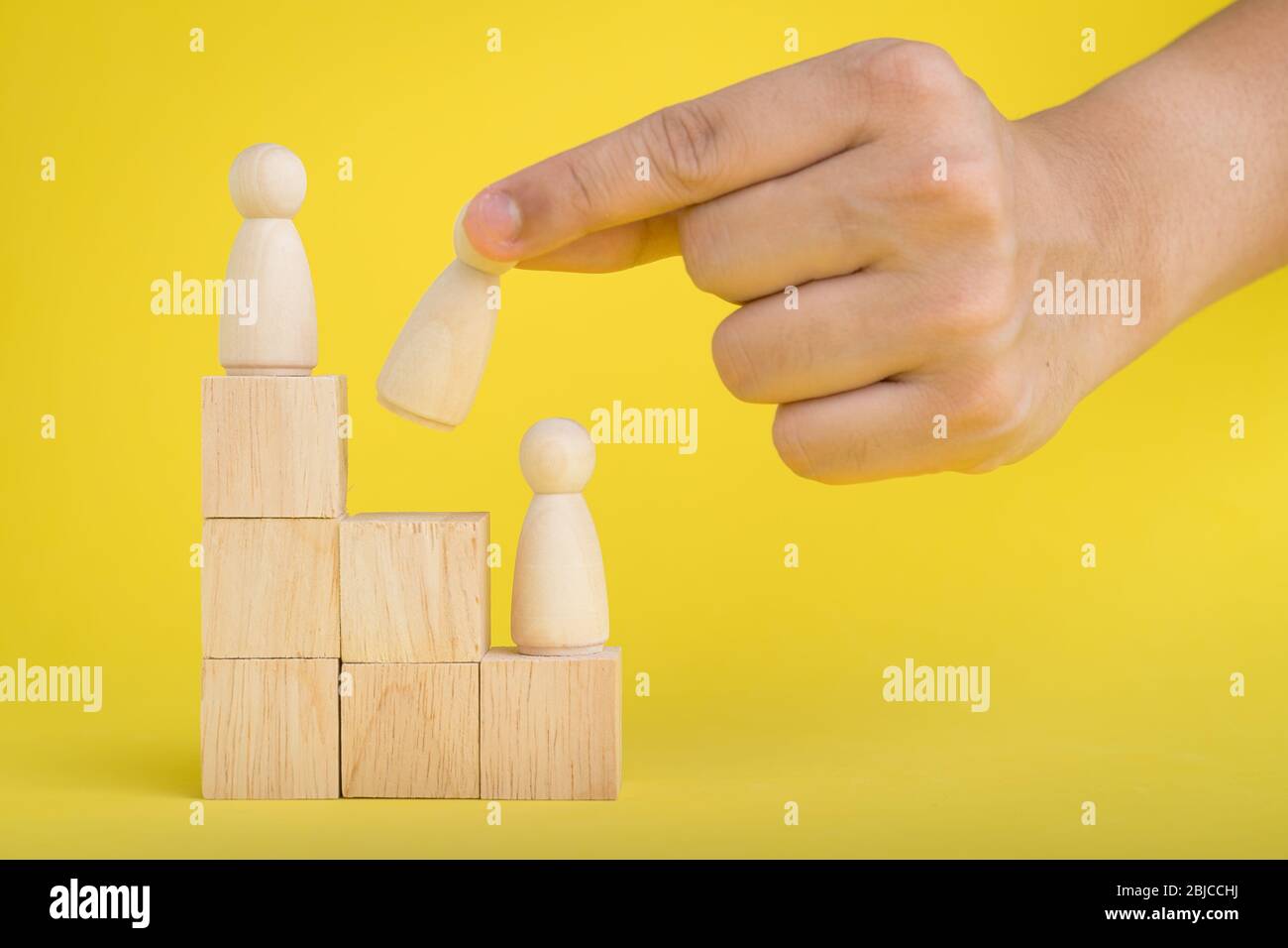 Die Hand ist Kommissionierung oder wählen Sie Holzfigur auf dem Holz gestapelt in Personalmanagement-Konzepte Teamwork.Success Leadership,Business Progress A Stockfoto