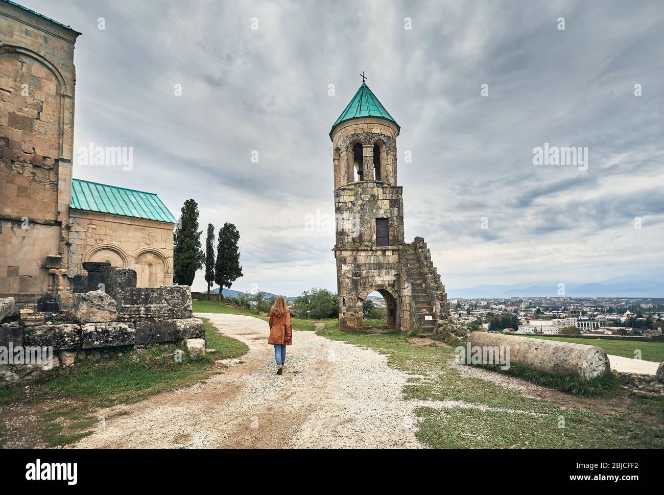 Frau zu Fuß von der Kapelle Turm von bagrati Kirche bei bedecktem Himmel in Kutaissi, Georgien Stockfoto