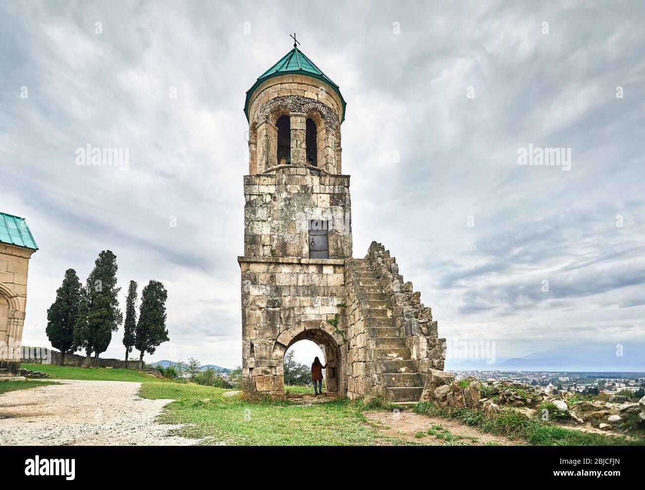 Frau touristische im Bogen der Kapelle Turm von bagrati Kirche bei bedecktem Himmel in Kutaissi, Georgien Stockfoto