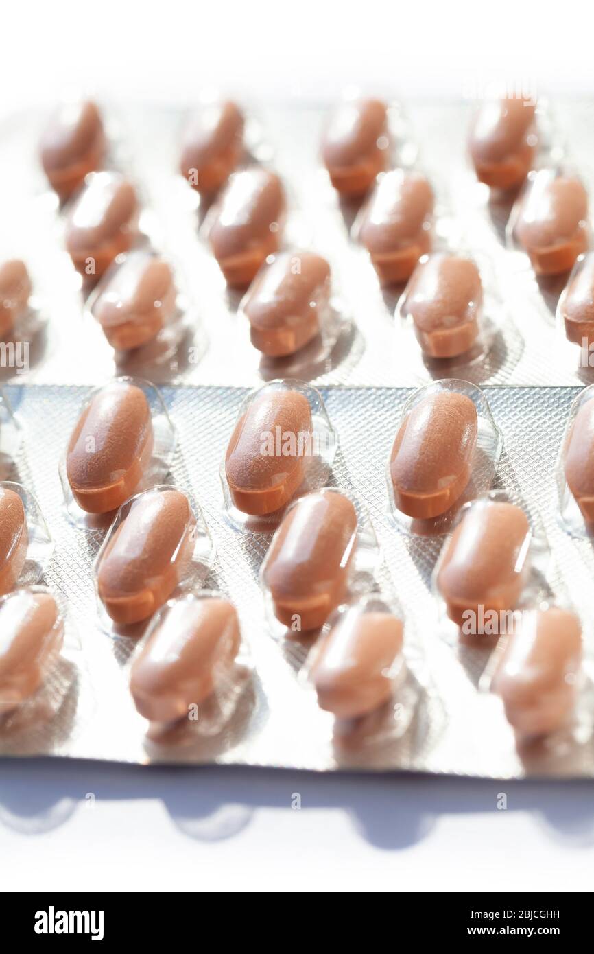 Mehrere Kapseln in Blisterpackungen, Packungen Nahaufnahme. Pillen, orange Tabletten in einfachen Kunststoff-Verpackung Behälter aus der Nähe gesehen, Apotheke Konzept Stockfoto