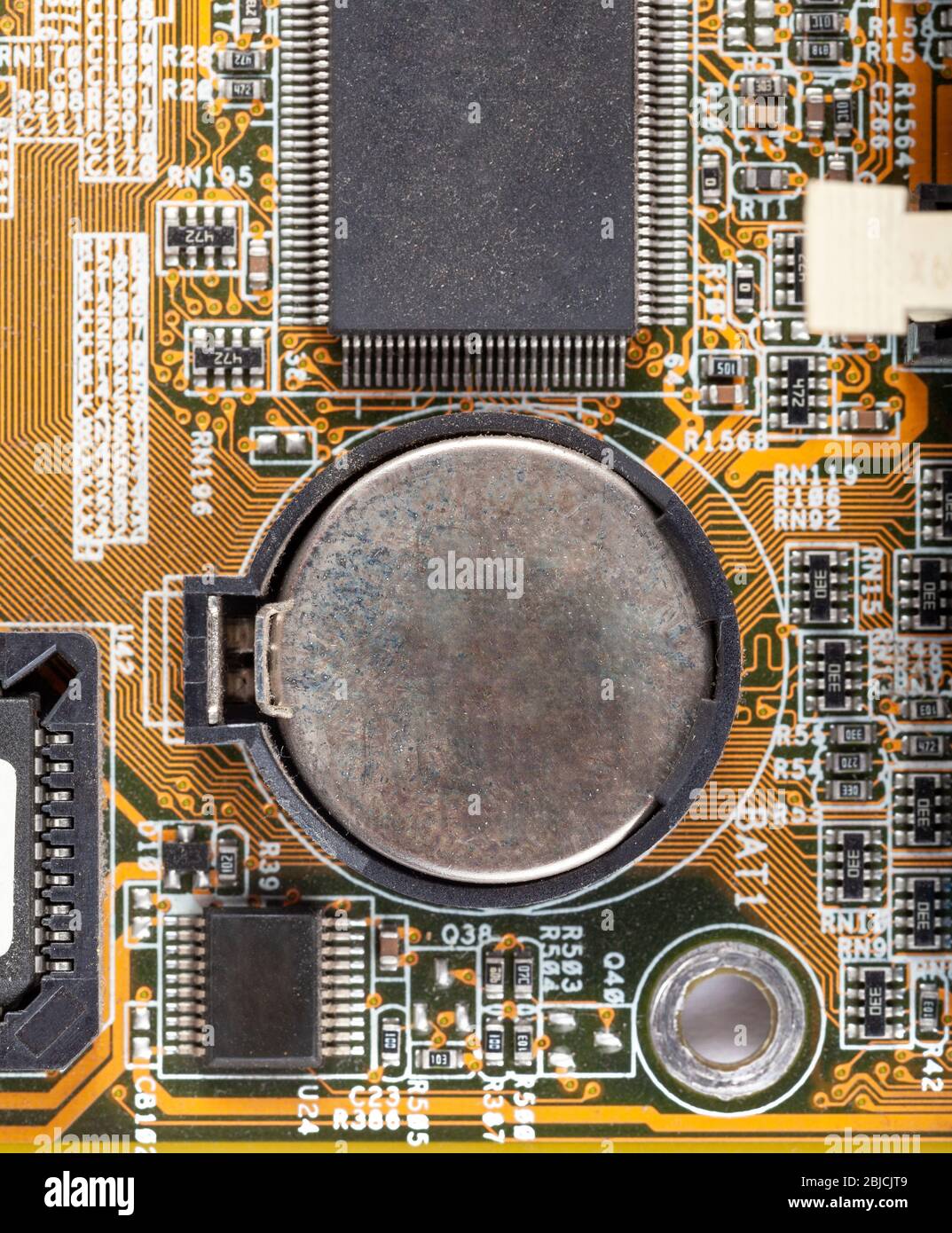Leere alte verrostete CMOS-Batterie auf dem Mainboard Makro, Nahaufnahme, einfache Draufsicht, von oben. Ersetzen der bios-Batterie auf der pc-Hauptplatine Stockfoto