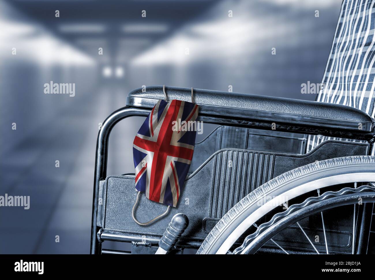 Flagge von Großbritannien Großbritannien auf Gesichtsmaske hängen auf leeren Rollstuhl im Flur des britischen Krankenhauses oder Ruhestand Pflegeheim mit Kopierraum. Stockfoto