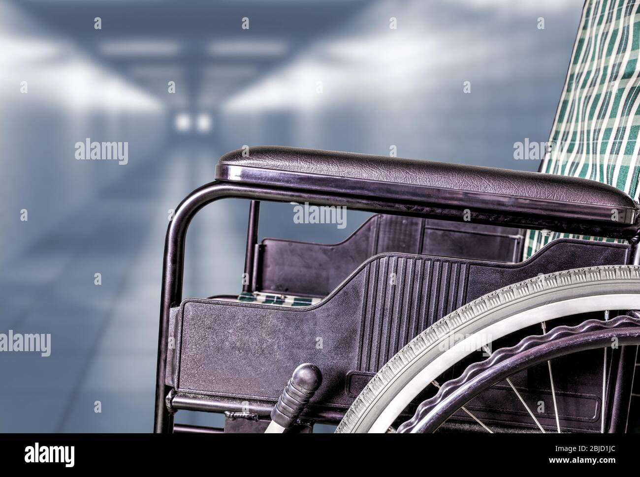 Leerer Rollstuhl im Flur des Krankenhauses oder Altenpflegeheims mit Kopierplatz. Konzept der Krankheit, Einsamkeit, Vernachlässigung, Isolation durch pa Stockfoto