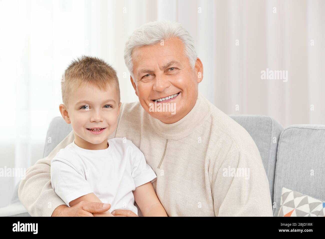 Glücklicher Großvater mit Enkel auf Couch Stockfoto