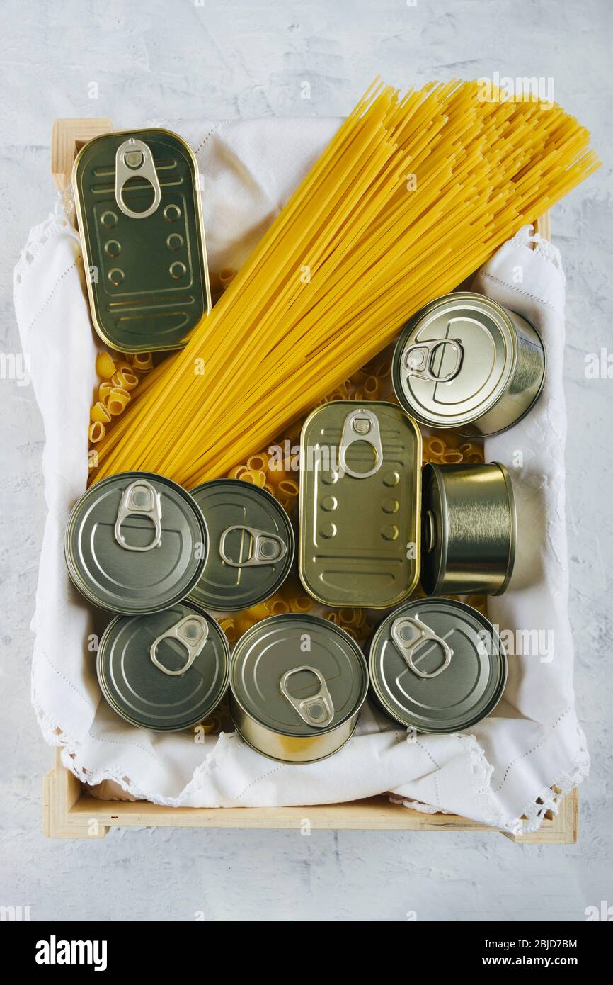 Draufsicht auf eine Schachtel mit verschiedenen Dosen von nicht verderblichen Lebensmitteln und Pasta wie Spaghetti. Halten Sie Lebensmittel zu Hause für Situationen wie Quarantäne aufgrund von Cov Stockfoto