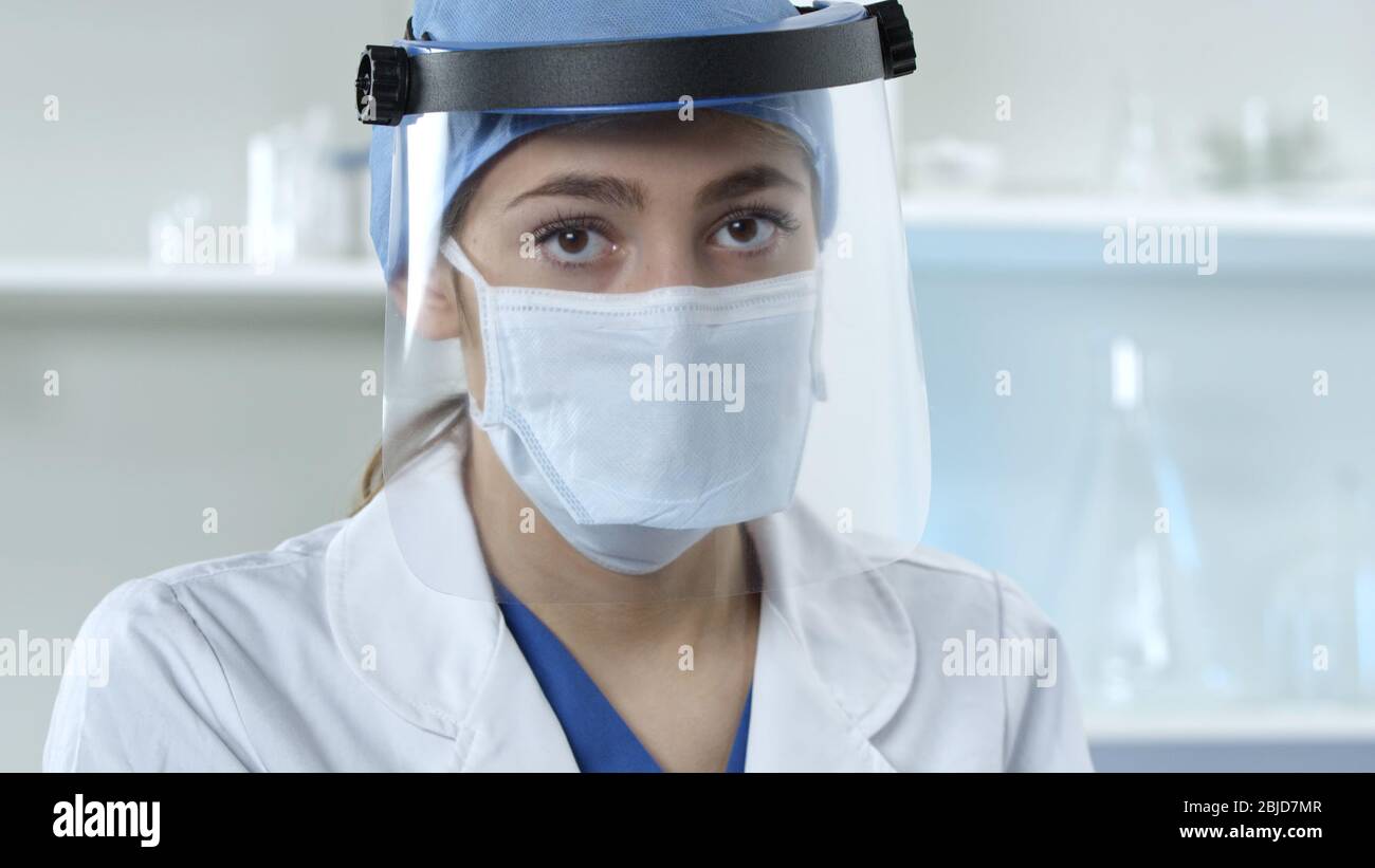 Weibliche Doktor trägt Gesichtsmaske und Schild Stockfoto