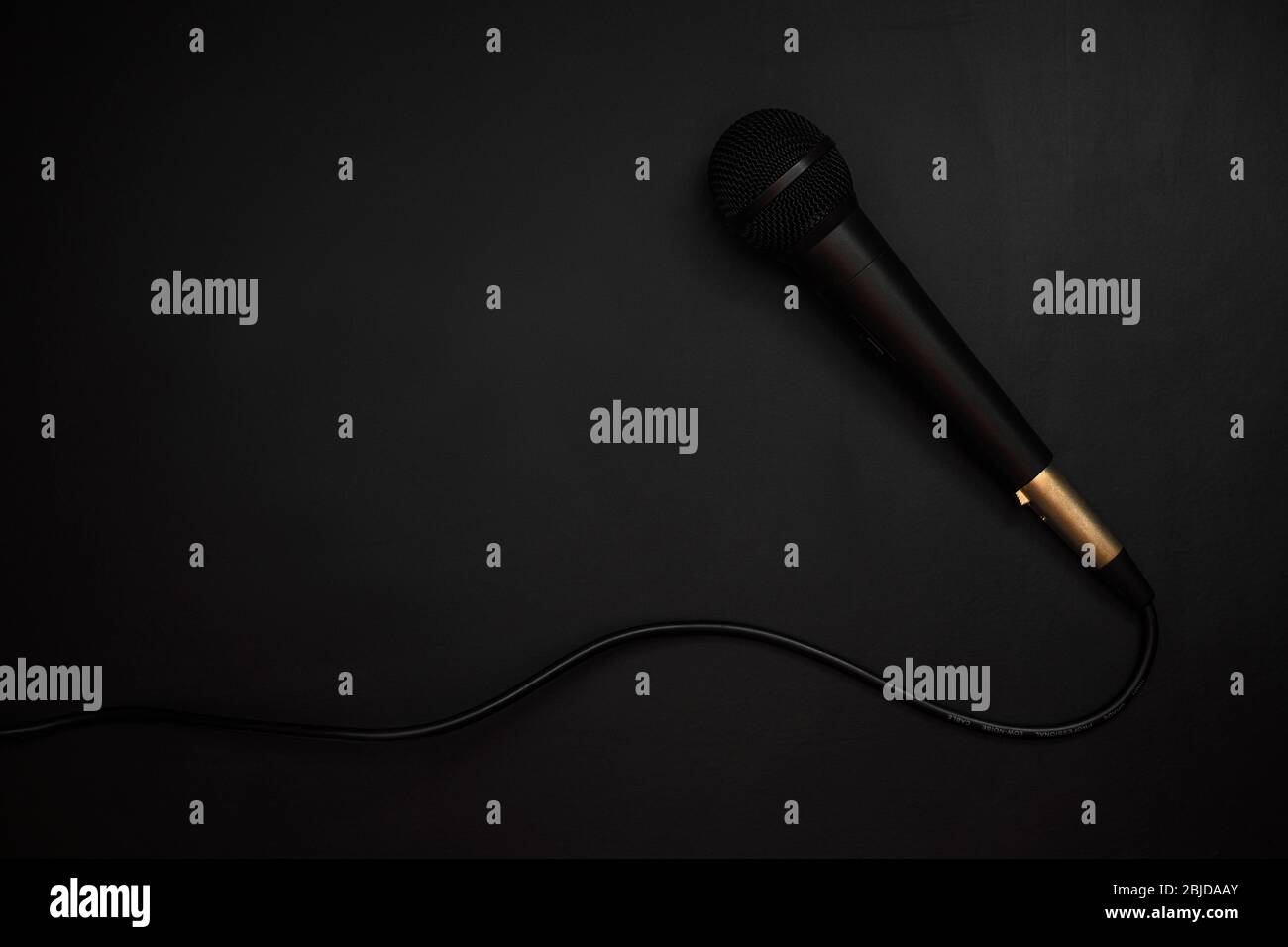 Schwarzes Kabelmikrofon auf schwarzem Hintergrund Stockfoto