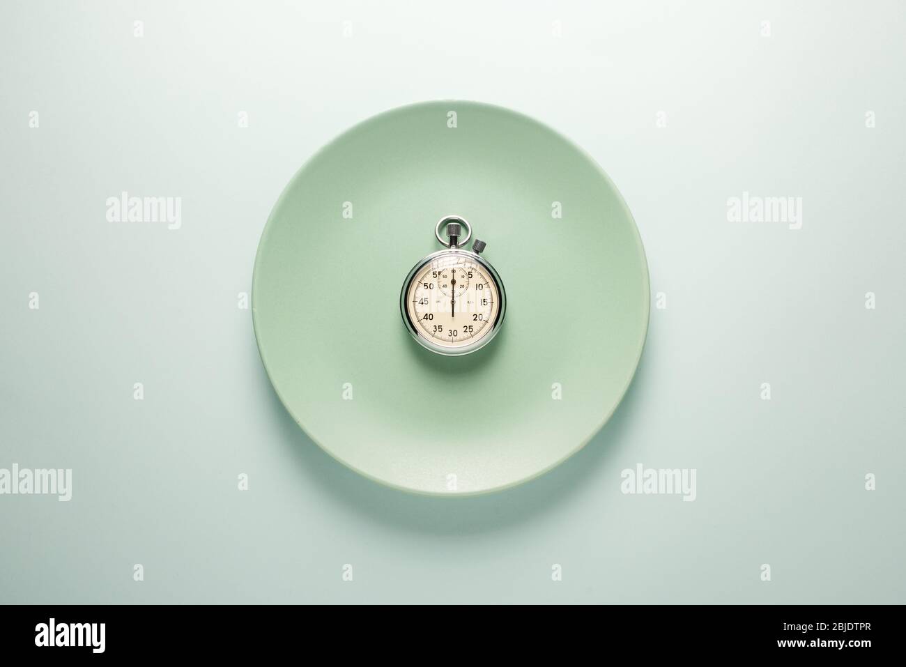 Türkisfarbene Platte mit Stoppuhr auf hellem Hintergrund Draufsicht. Fast Food Konzept. Stockfoto