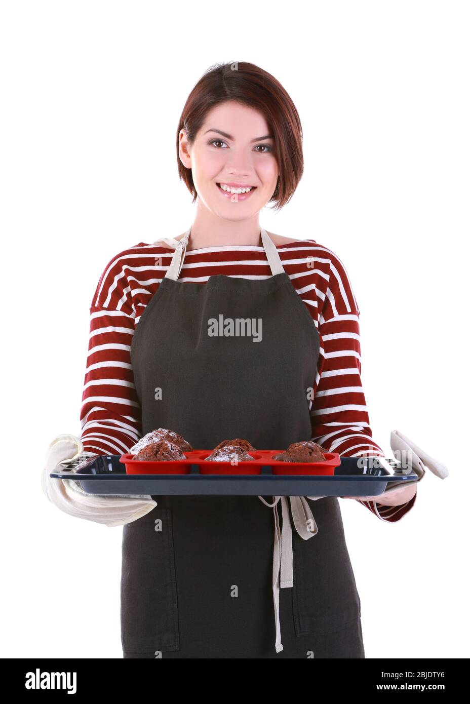 Junge Frau hält Backblech mit leckeren Schokolade Muffins auf weißem Hintergrund Stockfoto