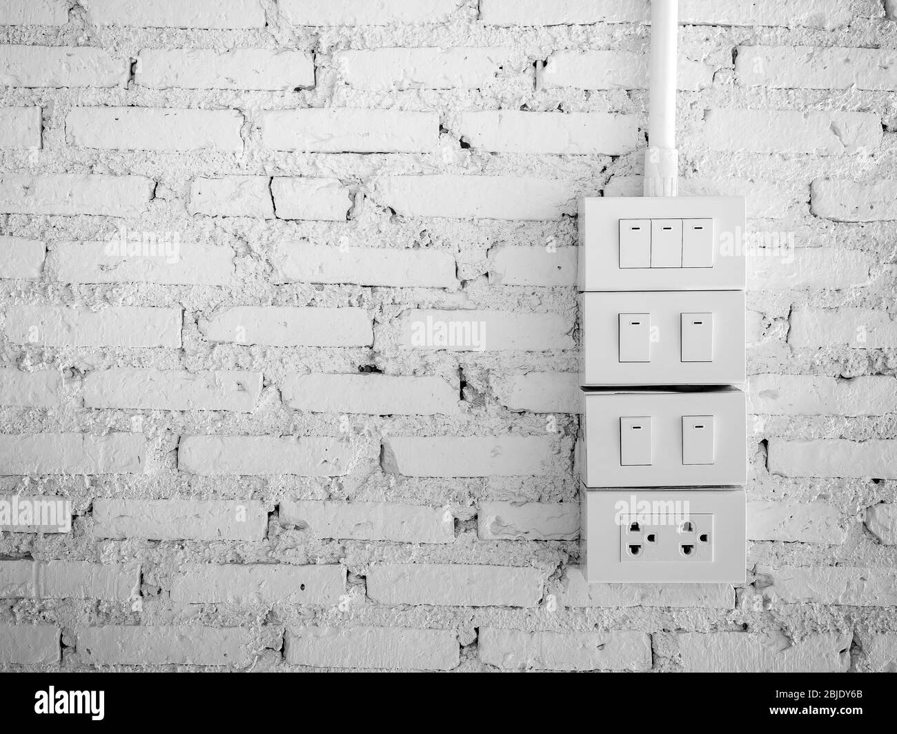 Gruppe von Lichtschalter und Steckdose Stecker, weiße Farbe auf grunge weißen Backstein Wand Hintergrund mit Kopierraum. Stockfoto