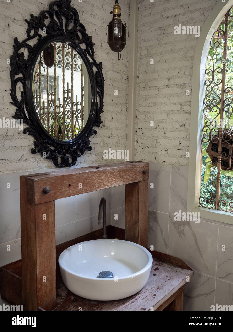 Weiße saubere Keramik Waschbecken Bad und Wasserhahn auf Vintage Holztisch  und Vintage-Spiegel auf weißen Backstein Wand Hintergrund in der Nähe  schmiedeeisernen Fenster, vertikalen Stil Stockfotografie - Alamy