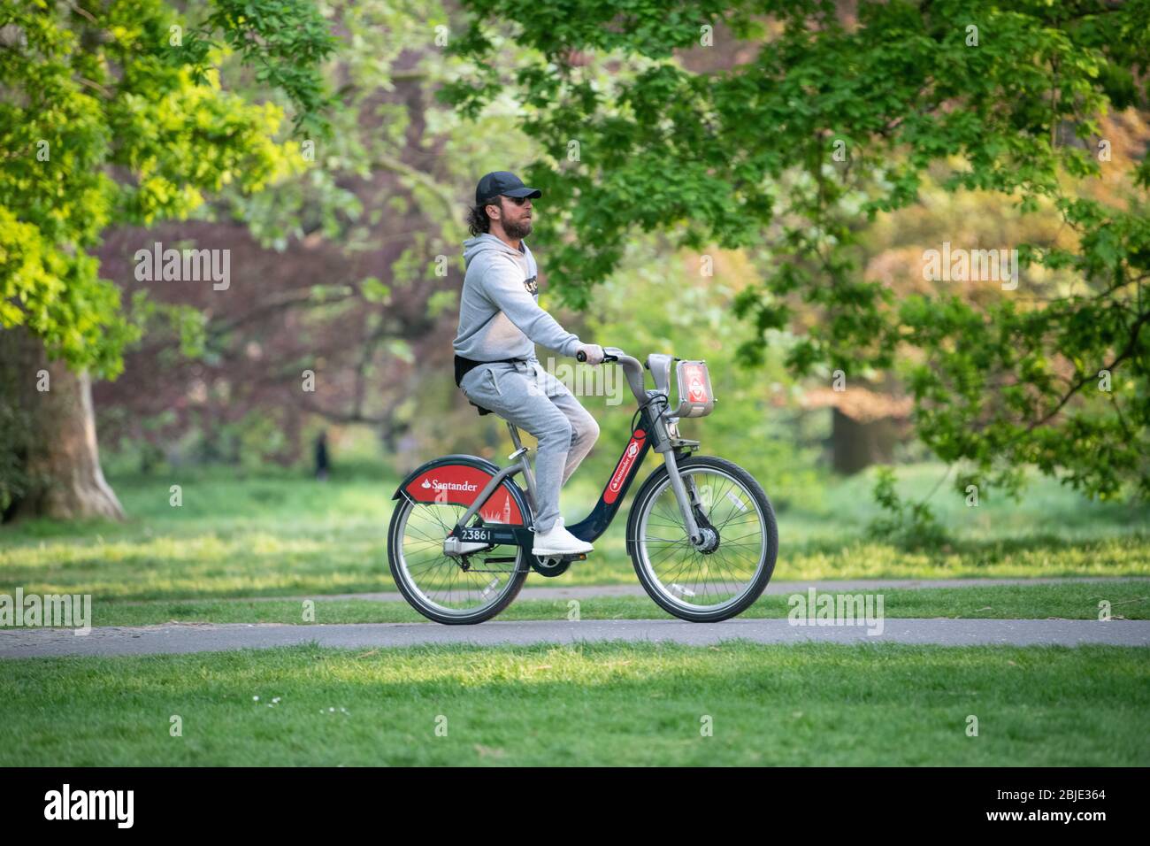 Radfahrer auf gemieteten Santander Fahrrad mit Schutzhandschuhen und in London Lockdown. Stockfoto