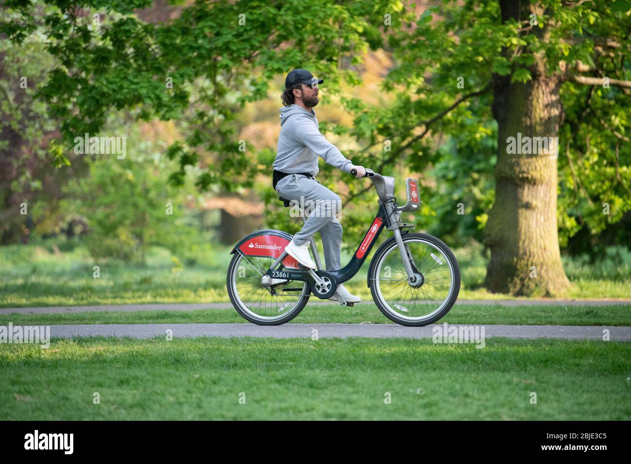 Radfahrer auf gemieteten Santander Fahrrad mit Schutzhandschuhen und in London Lockdown. Stockfoto