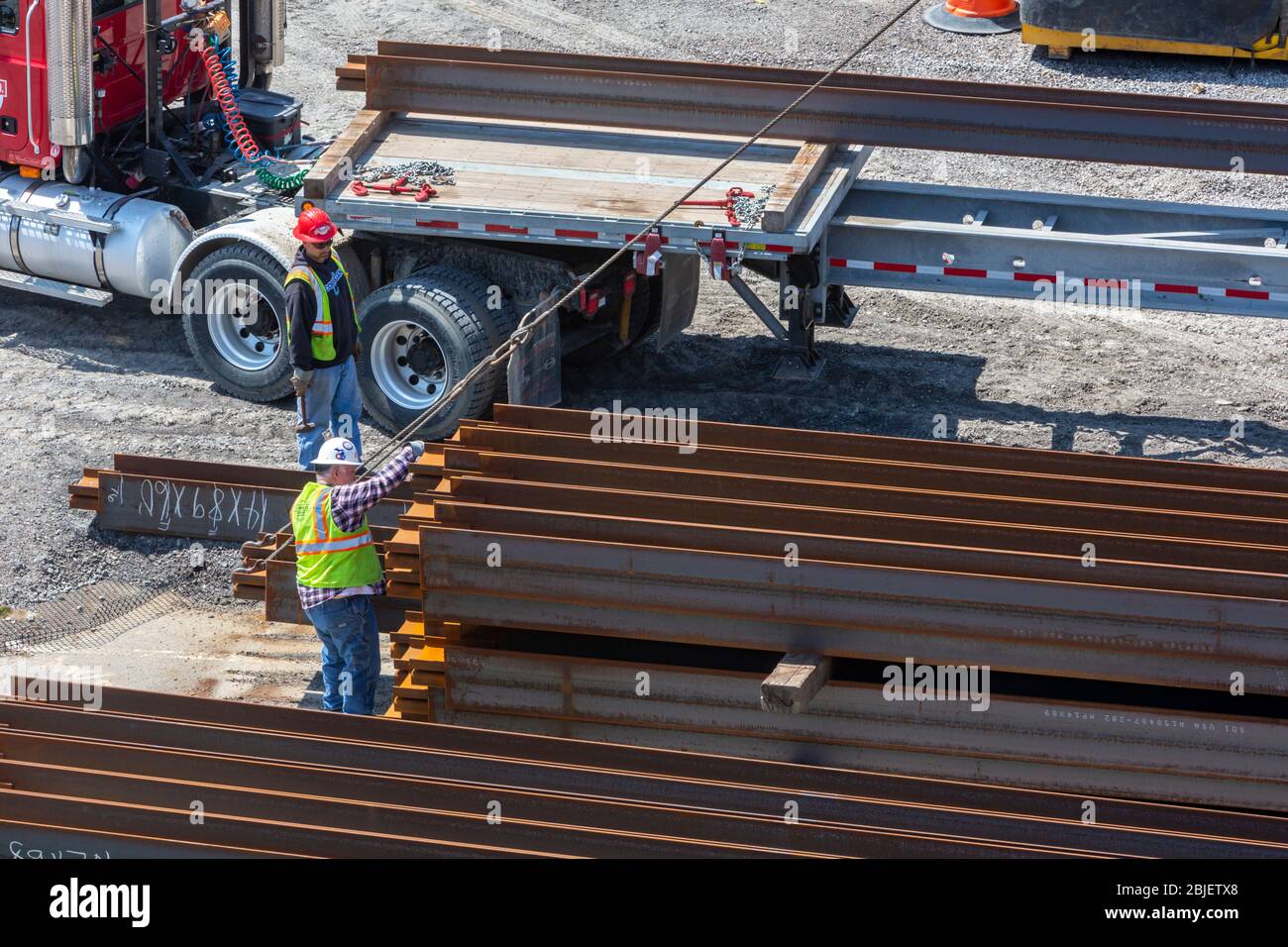 Detroit, Michigan - Arbeiter entladen Stahlpfähle von einem LKW. Die Anhäufung wird als Stütze für eine Brücke verwendet, die über die Interstate 94 rekonstruiert wird. Stockfoto