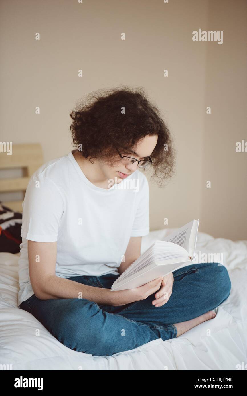 Teenager lesen Buch auf dem Bett zu Hause. Stockfoto