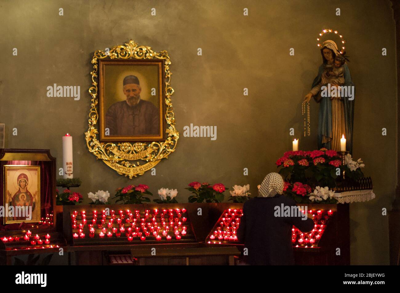 Redan Alte Frau lits eine Votivkerze Stockfoto