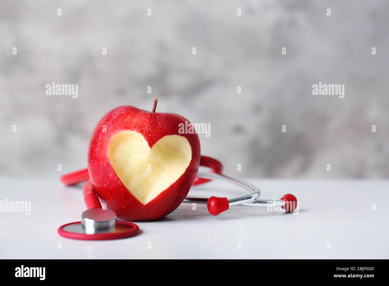 Apfel mit Stethoskop auf farbigem Hintergrund Stockfoto