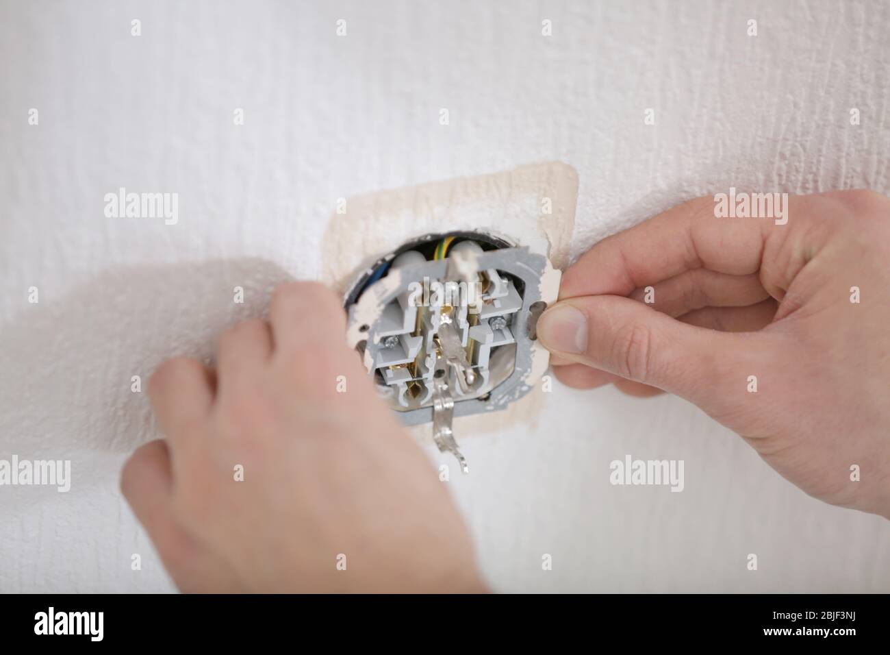 Hände des Elektrikers Installation der Steckdose, Nahaufnahme Stockfoto