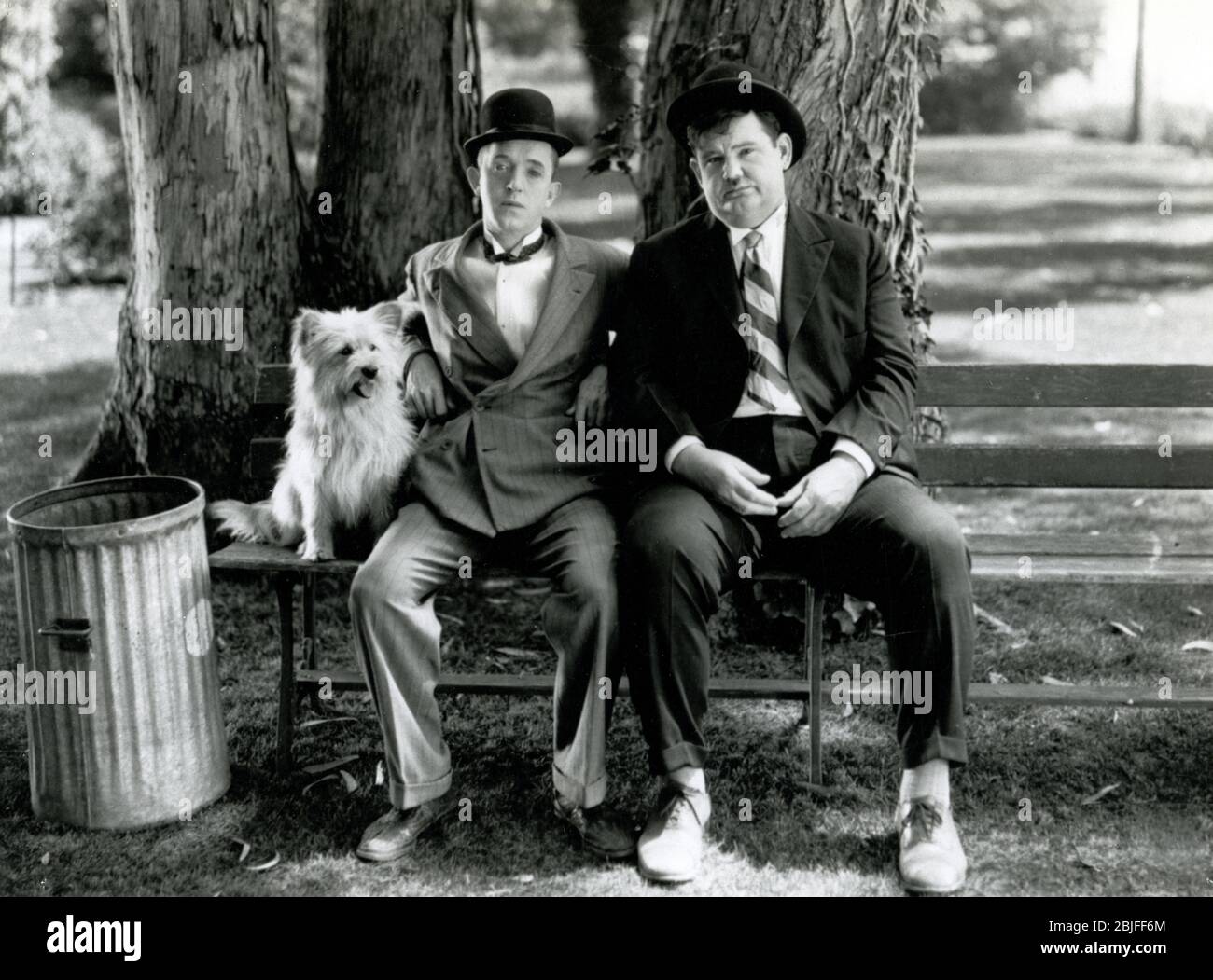 Laurel und Hardy sitzen auf einer Parkbank in einer Szene aus einem klassischen Stummfilm-Sujet, 'Early to Bed', 1928 von MGM. Stockfoto