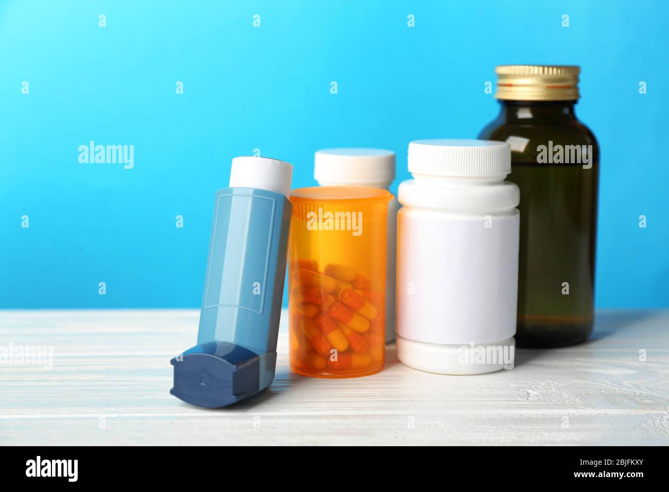 Asthma-Inhalatoren mit Medikamenten auf blauem Hintergrund Stockfoto