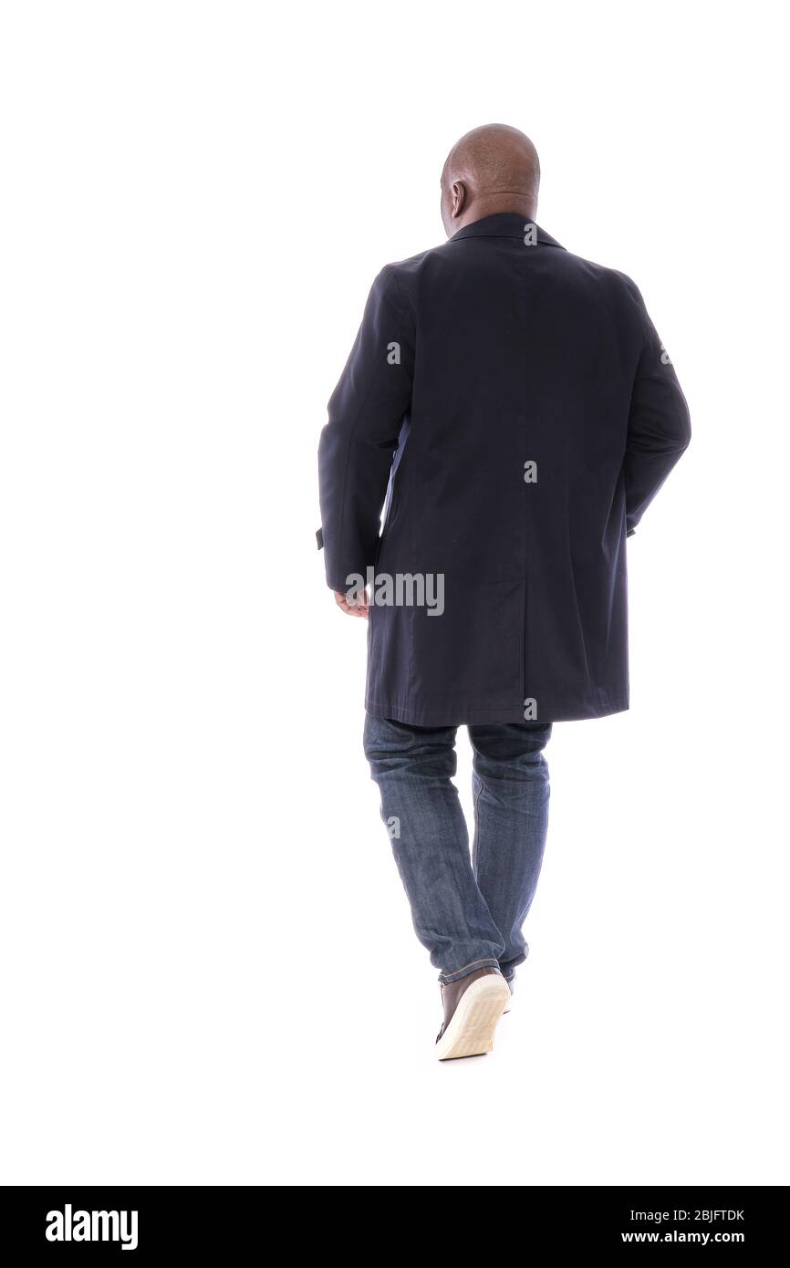 Ganzkörper männliche Figur zurück zur Kamera Ansicht des afroamerikanischen Mann in marineblauen Trenchcoat mit blauen Denim Jeans und lässigen braunen Schuhen Stockfoto