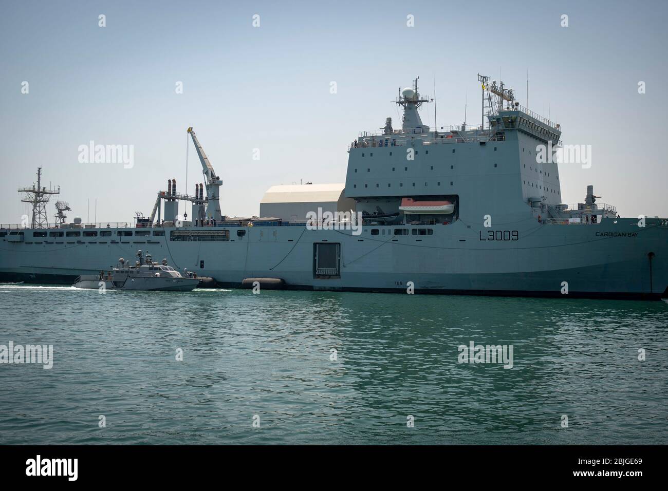 MANAMA, Bahrain (24. April 2020) EIN Mark VI Patrouillenboot, das der Kommandant Task Force 56 zugewiesen wurde, kommt neben dem Royal Fleet Auxiliary Landing Ship Dock RFA Cardigan Bay (L3009), um im April 24 eine simulierte Auffüllung auf See durch Rafting im Hafen durchzuführen. CTF 56 ist für die Planung und Durchführung von Expeditions-Missionen einschließlich Küstenflußeinsätzen im 5. Einsatzgebiet der US-Flotte verantwortlich. (USA Navy Foto von Mass Communication Specialist 1. Klasse Kory Alsberry) Stockfoto